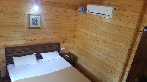 1 dormitorio con 1 cama en una pared de madera en Casa de Kihim, en Alibaug