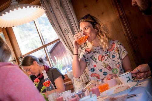 a woman eating food while sitting at a table at Pension der Steinbock - das 300 Jahre alte Bauernhaus - TIROL in Sankt Anton am Arlberg
