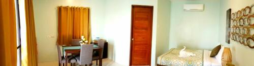 a room with a bed and a table with a mirror at Tropical Fun Ta Sea Rentals in Siquijor