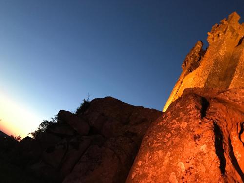 a view of the sun setting behind a rock formation at Hotel Medieval® de Penedono in Penedono