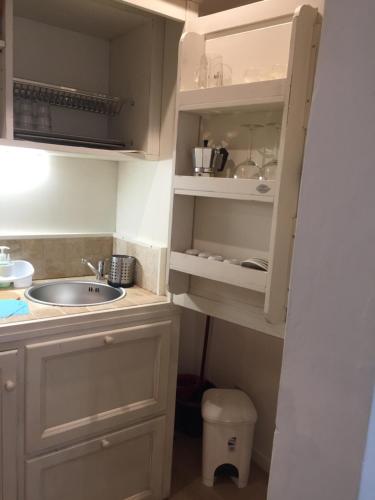 フィレンツェにあるDuomo Residence Florenceの白いキャビネット、シンク、トイレ付きのキッチンが備わります。