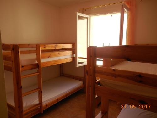 a room with two bunk beds and a window at Les Cigales du Ventoux in Le Barroux