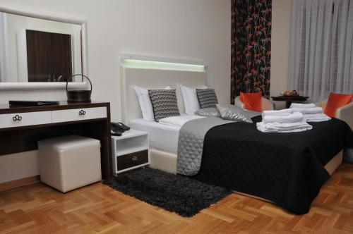a bedroom with a bed and a vanity and a mirror at Apartments Biser in Vrnjačka Banja