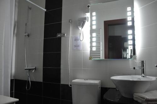 a bathroom with a sink and a toilet and a mirror at Apartments Biser in Vrnjačka Banja