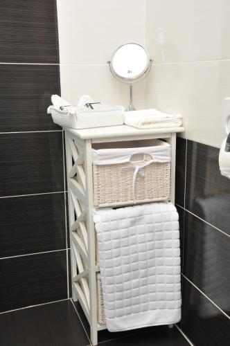 a bathroom with a shelf with towels and a mirror at Apartments Biser in Vrnjačka Banja