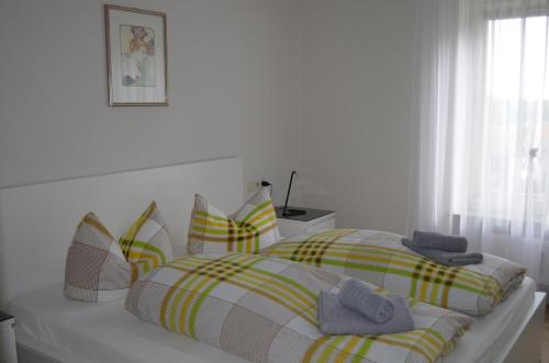 ブラウンラーゲにあるSonnenglück mit Schwimmbadの白いベッドルーム(カラフルな毛布と枕付きのベッド付)