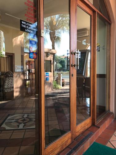 a glass door of a store with a sign on it at The Elegant Lodge Menlo Park in Pretoria