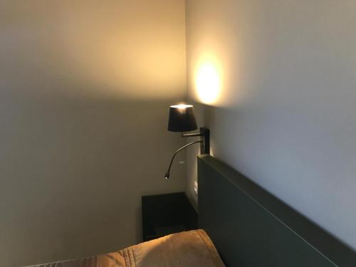 a bedroom with a bed and a lamp on the wall at Hotel Medieval® de Penedono in Penedono