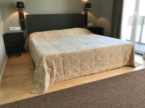 a bedroom with a bed with a blanket on it at Hotel Medieval® de Penedono in Penedono