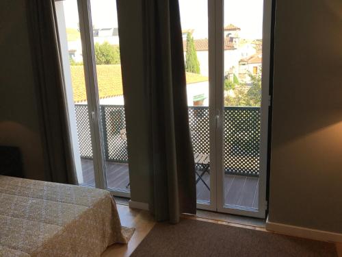 a bedroom with doors open to a balcony at Hotel Medieval® de Penedono in Penedono