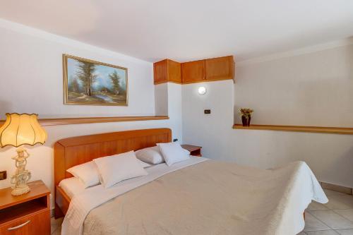 a bedroom with a large bed with white sheets at Apartmani Mužić in Orlec