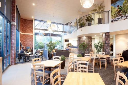 a restaurant with tables and chairs and people sitting at Ventura Inn & Suites Hamilton in Hamilton