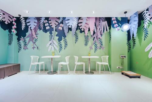 a room with tables and chairs and a wall with leaves at CityInn Hotel Taipei Station Branch II in Taipei