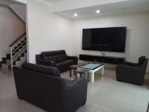 a living room with couches and a flat screen tv at Sri Manjung Ma Maison Homestay in Lumut