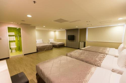 a hotel room with two beds and a television at Palmer Hotel in Taichung