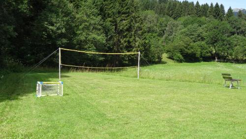 a net in a field with a bench and a goal at Ferienhaus Enzi in Weissbriach