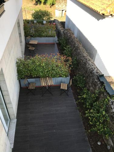 a patio with two benches and some plants at Hotel Medieval® de Penedono in Penedono