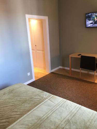 a room with a bed and a table and a door at Hotel Medieval® de Penedono in Penedono