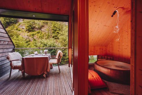 a room with a table and a tub on a deck at House Raduha in Luče