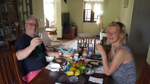 a man and woman sitting at a table with drinks at Grace Green Ville in Negombo