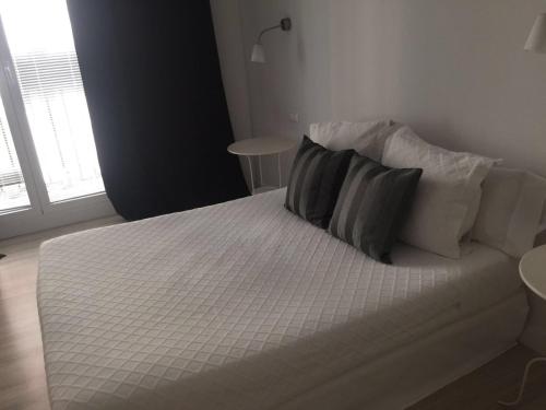 マドリードにあるCalle Aduanaの白いベッド(枕2つ付)が備わるベッドルームです。