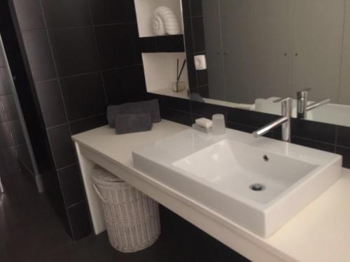 a bathroom with a white sink and a mirror at Calle Aduana in Madrid