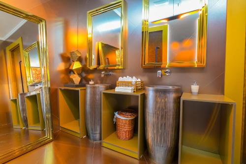 a bathroom with two trash cans and mirrors at The ONE Hotel Astana in Astana