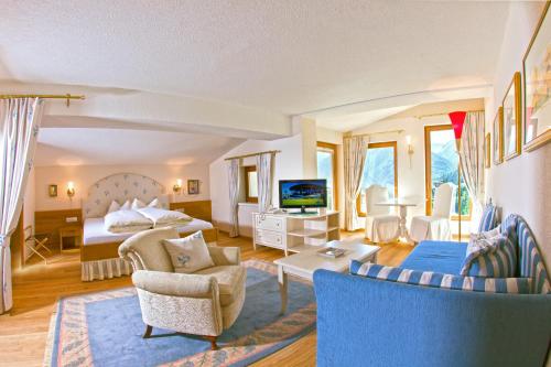 a hotel room with a bed and a living room at Hotel Garni Zerzer in Serfaus