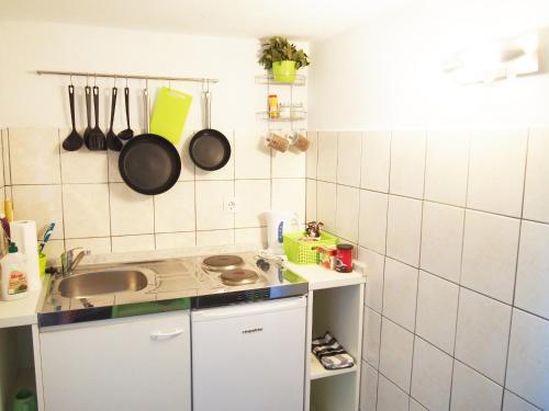 una cucina con lavandino e utensili appesi al muro di Apartment Nives a Zara (Zadar)