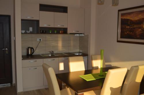 a kitchen with a wooden table and a dining room at Apartments MM in Sveti Stefan
