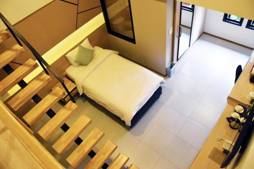 a small bed in a room with a staircase at TUCK Me iN in Chiang Mai