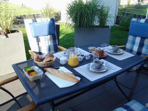 une table bleue avec des aliments pour le petit-déjeuner dans l'établissement La Maison De Roméo, à Bergheim