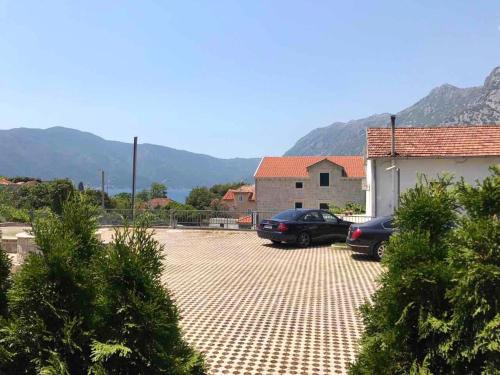 two cars parked in a parking lot next to a building at Roman Garden Apartment in Risan