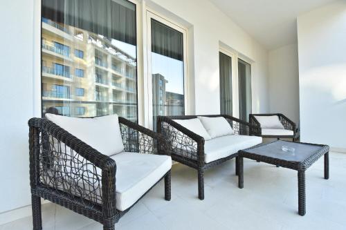 a balcony with chairs and a table and windows at Lux Apartments Sunrior in Budva