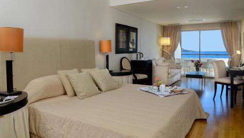 ein Wohnzimmer mit einem großen weißen Bett in einem Zimmer in der Unterkunft Plaza Resort in Anavyssos
