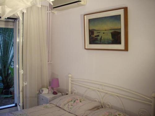 アテネにあるLilly's Appartmentsのベッドルーム1室(ベッド1台付)が備わります。壁に絵が飾られています。