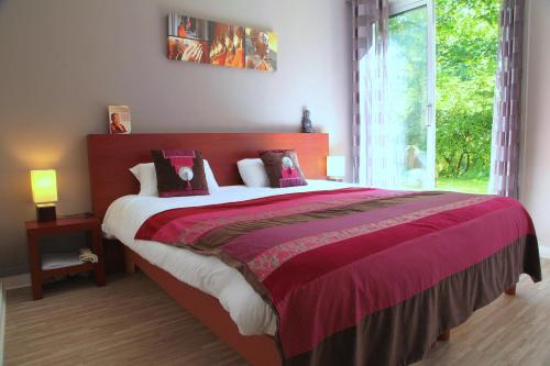 a bedroom with a large bed with a large window at Logis Latitude Ouest Hôtel Restaurant & Spa in Locronan