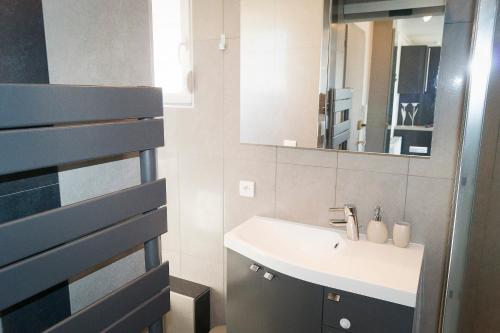 a bathroom with a sink and a mirror at En attique - Residence le Ronsard in Sélestat