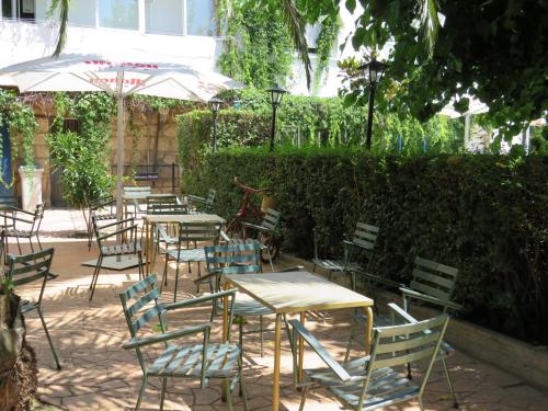 a group of tables and chairs with an umbrella at Hostal San José in Cadalso de los Vidrios