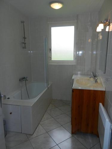 a bathroom with a tub and a sink and a bath tub at Orbigny Vakantiewoningen in Saint-Pierre-la-Vieille