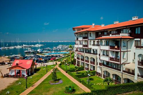 a building with a red roof next to a marina at Apartment in Luxury Resort Sveti Vlas in Sveti Vlas