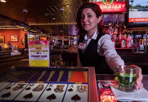 a woman standing behind a bar with a drink at Skyline Hotel and Casino in Las Vegas