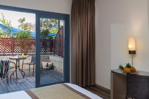 a hotel room with a balcony with a table and a patio at Leonardo Hotel Jerusalem in Jerusalem