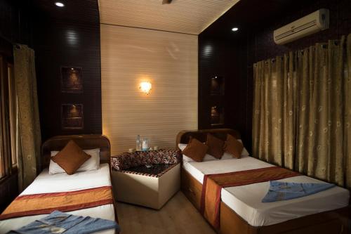 a room with two beds and a couch in it at Chitwan Forest Resort , Chitwan National Park in Sauraha