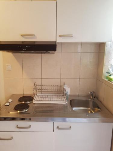 a kitchen with a sink and a dish rack on the counter at Apartments Andrea in Šibenik