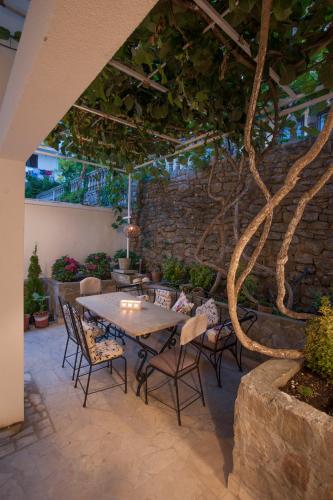 a table and chairs in a patio with a tree at Apartments Captain's Villa in Budva