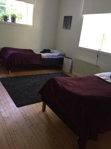 a bedroom with two beds and a rug at Domsjö Apartment in Örnsköldsvik