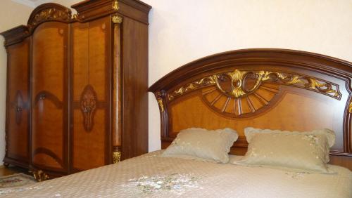 a wooden bed with two pillows on top of it at Apartment vake-saburtalo in Tbilisi City