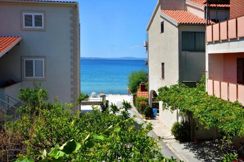 a view of the beach from between buildings at m & m in Podstrana
