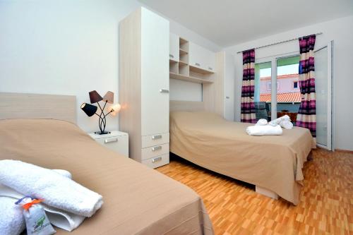 a small bedroom with two beds and a window at m & m in Podstrana